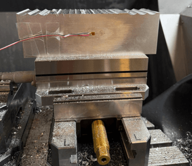 Strain gauge mounted on CNC test setup